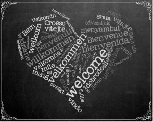 heart shape on chalkboard with welcome in different languages photo