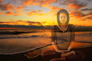 woman meditating at sunset photo