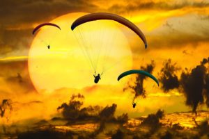 paragliders in yellow sunset image