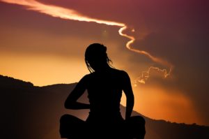 woman meditating at sunset photo